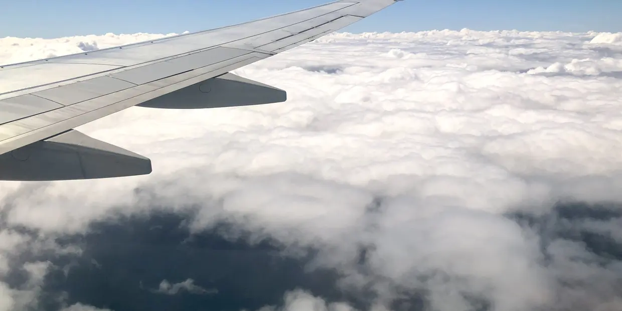 An aircraft wing above a floor of cloud, seen from the cabin window