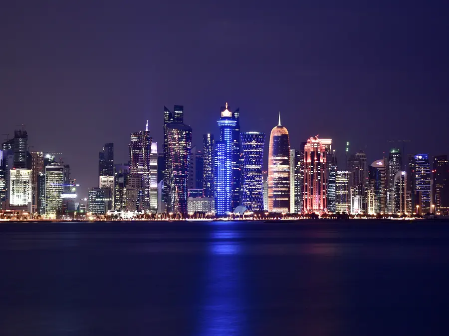 The lit towers of Doha’s West Bay reflected in the bay at night